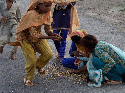 Pakistani_Flood_Victims_with_spilled_aid.jpg image